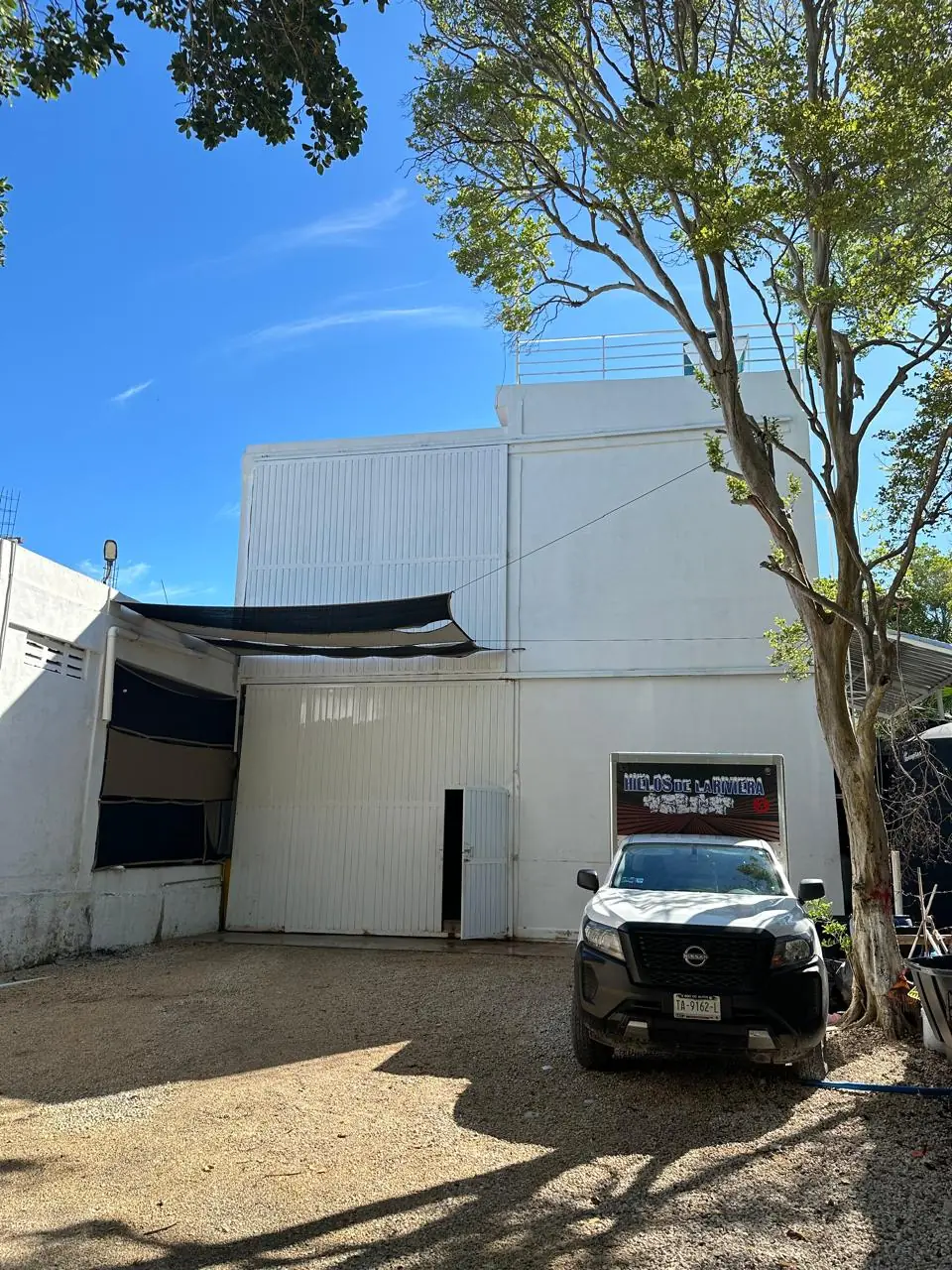 Nave de la fábrica de Hielos de la Riviera, con su portón de carga y el rótulo de la empresa.
